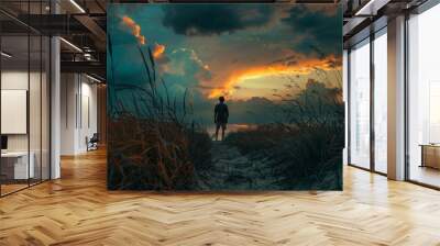 A man stands in a field of tall grass, looking out at the sky Wall mural