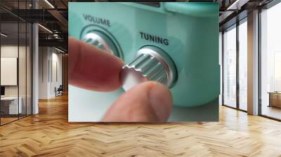 closeup of hand of man turning vintage fifties style radio buttons on white background Wall mural