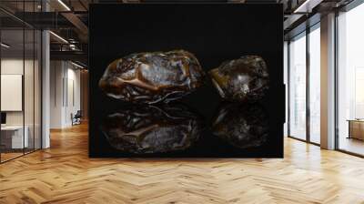 Group of two whole dried brown date medjool isolated on black glass Wall mural