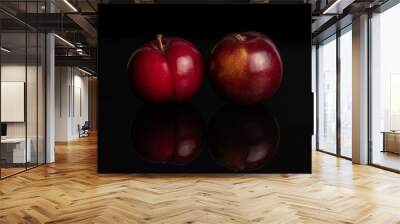 Group of two whole ripe red round plum isolated on black glass Wall mural