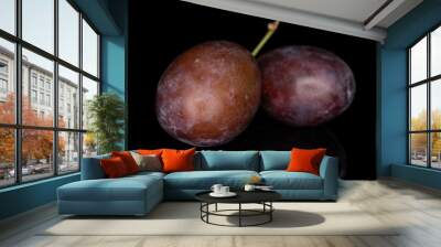 Group of two whole sweet purple plum isolated on black glass Wall mural