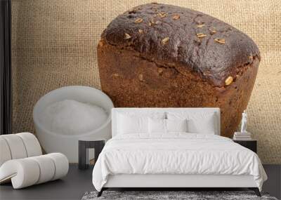 One whole fresh baked dark bread with pinch of salt on jute cloth Wall mural