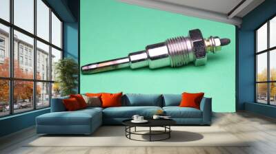 Glow plug for diesel engine which is auto spare part that is necessary for engine to start by heating the internal combustion part on green background Wall mural