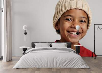 A young African-American boy sports a warm friendly smile while donning a red sweater and beige knit hat Wall mural