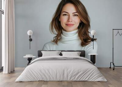 Studio portrait of a young happy woman looking to the camera, light grey background, wearing a turtle neck Wall mural