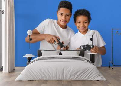 African-American boys playing video game on color background Wall mural