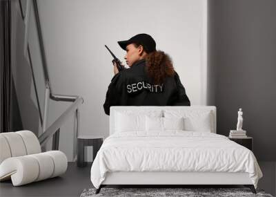 African-American female security guard with radio transmitter in building, back view Wall mural