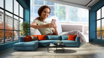 African-American female soldier with mobile phone at home Wall mural