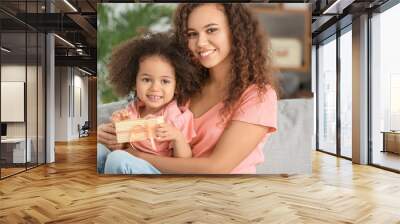 African-American woman with gift for Mother's Day received from her little daughter at home Wall mural