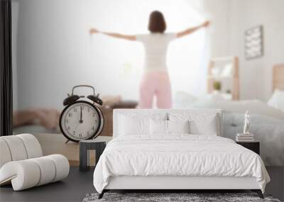 Alarm clock on table in bedroom of young woman Wall mural