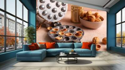 Baking form with tasty walnut shaped cookies and tin can of boiled condensed milk on color table Wall mural