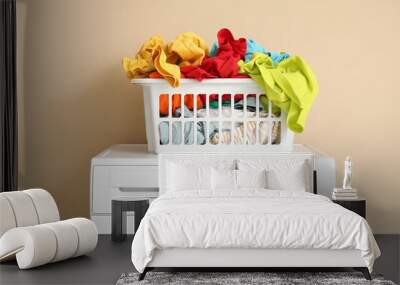 Basket with dirty clothes on washing machine near beige wall, closeup Wall mural