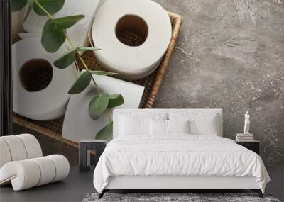 Basket with rolls of toilet paper and eucalyptus branch on grunge background Wall mural