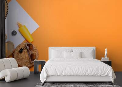 Beach accessories, world map, compass and bottle of sunscreen on orange background with space for text Wall mural