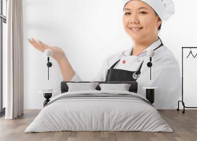 Beautiful Asian chef showing something on white background Wall mural