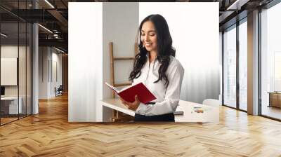 Beautiful Asian woman with book in office Wall mural