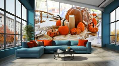 Beautiful autumn table setting with pumpkins and candles in room Wall mural