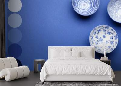 Beautiful Chinese bowls on blue background. Different color patterns Wall mural