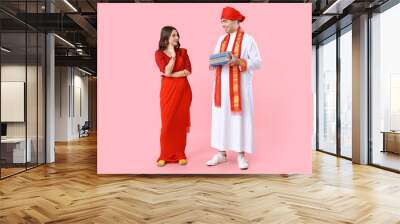 Beautiful Indian couple with books on pink background Wall mural