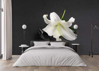 Beautiful lily flower with black funeral ribbon on dark background Wall mural