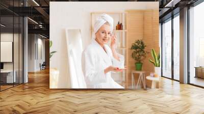 Beautiful mature woman with jar of cream in bathroom Wall mural