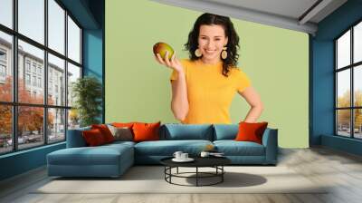 Beautiful woman with fresh mango on color background Wall mural