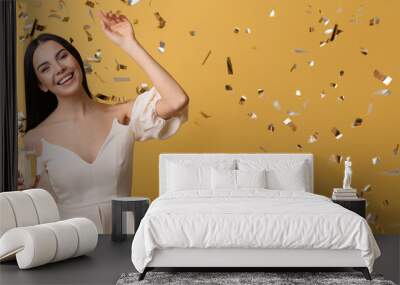 Beautiful woman with glass of champagne and falling confetti on color background with space for text Wall mural