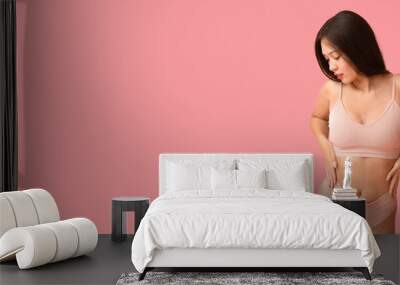 Beautiful young Asian woman in underwear on pink background with space for text Wall mural