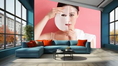 Beautiful young Asian woman with sheet facial mask on color background Wall mural