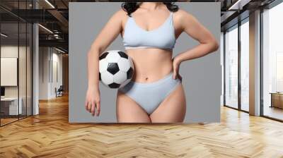 Beautiful young body positive woman with soccer ball in stylish underwear on grey background, closeup Wall mural