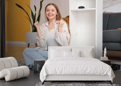 Beautiful young happy woman assembling white shelving unit at home Wall mural