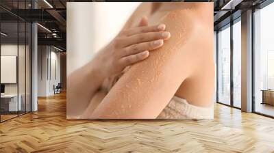 Beautiful young woman applying body scrub at home, closeup Wall mural