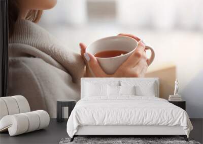 Beautiful young woman drinking tea at home, closeup Wall mural