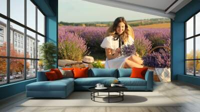 Beautiful young woman having picnic in lavender field Wall mural