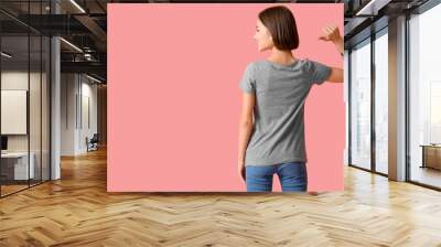 Beautiful young woman in stylish t-shirt on color background, back view Wall mural