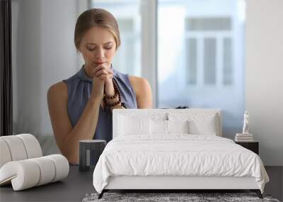 Beautiful young woman praying in office Wall mural