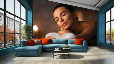 Beautiful young woman relaxing in spa salon Wall mural