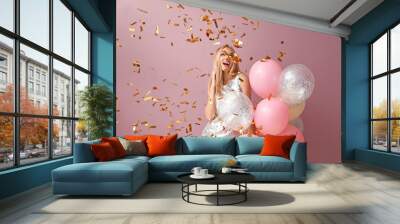 Beautiful young woman with air balloons and falling confetti against color background Wall mural