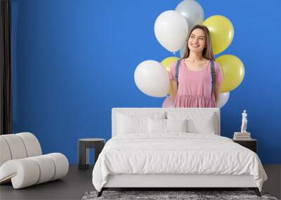 Beautiful young woman with balloons on color background Wall mural