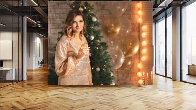 Beautiful young woman with champagne in room decorated for Christmas Wall mural