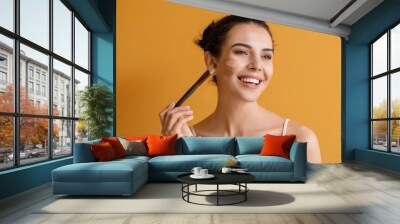 Beautiful young woman with foundation on her face against color background Wall mural