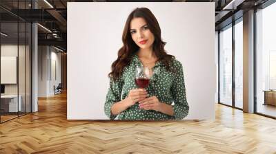 Beautiful young woman with glass of wine on light background Wall mural