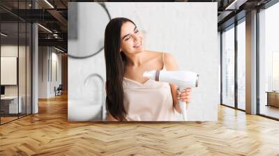 Beautiful young woman with hair dryer in bathroom Wall mural