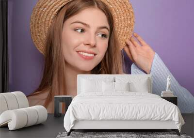 Beautiful young woman with hat on color background Wall mural