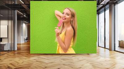 Beautiful young woman with ice cream near color wall Wall mural