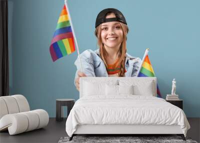 Beautiful young woman with LGBT flags on blue background Wall mural