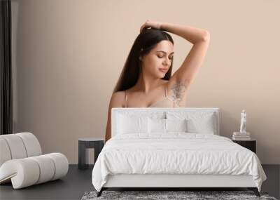 Beautiful young woman with razor and confetti on beige background. Depilation concept Wall mural