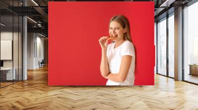 Beautiful young woman with tasty cookie on color background Wall mural