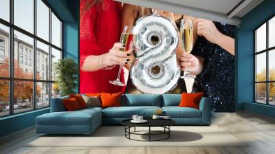 Beautiful young women with champagne and balloon in shape of figure 8. International Women's Day celebration Wall mural