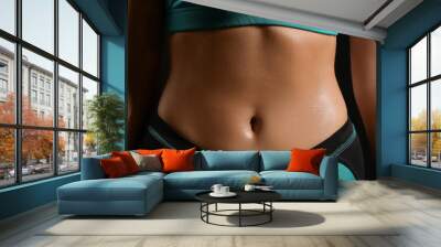 Belly of sporty young woman on black background, closeup Wall mural